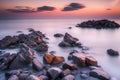 Beautiful seascape with long exposure of rocks and sea at sunset