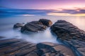 Beautiful seascape with long exposure of rocks and sea at sunset