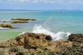 Seashores of New Zealand; beautiful seascape and bright blue ocean. Rocky foreground with clear and colourful waves.