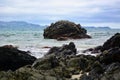 Seashores of New Zealand; beautiful seascape and bright blue ocean. Rocky foreground with clear and colourful waves.