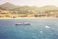 Beautiful seascape: rocky shore and a boat floating on the water. Toned Royalty Free Stock Photo