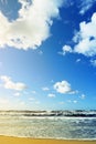 Beautiful seascape with sea waves, blue sky, white cumulus clouds and sand beach. Summer vacation tropical landscape. Royalty Free Stock Photo