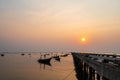 Beautiful seascape sunset with silhouette fishing wood boat floating down on sea at jetty in asia Royalty Free Stock Photo