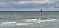 Beautiful seascape with two kitesurfers riding waves.