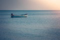 Beautiful seascape view of fishing boat floating on the sea with sunset light in the background. Royalty Free Stock Photo