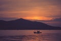 Beautiful seascape view of fishing boat floating on the sea with sunset light in the background at twilight time. Royalty Free Stock Photo