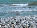 Beautiful seashore with waves and colored stones