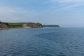 Beautiful seaside landscape with cliffs and green meadows on the shore