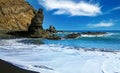 Beautiful secluded black lava sand beach, white wave foam, rock pillar, blue summer sky - Caleta playa Hermigua, La Gomera Royalty Free Stock Photo
