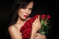 Beautiful young woman with a large bouquet of red roses Royalty Free Stock Photo