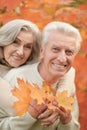 Beautiful senior couple in autumn park with leaves Royalty Free Stock Photo