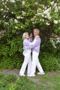 Beautiful senior couple dancing by lilacs in the park Royalty Free Stock Photo