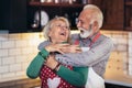 Senior couple is dancing and smiling while cooking together in kitchen. Quarantine. Health concept Royalty Free Stock Photo