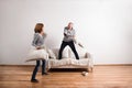 Beautiful senior couple having a pillow fight. Studio shot. Royalty Free Stock Photo