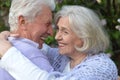 Beautiful senior couple hugging by lilacs in the park Royalty Free Stock Photo