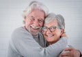 Beautiful senior couple of  people hugging each other with love - standing at home looking at camera  - serene retirement concept Royalty Free Stock Photo