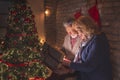 Senior couple opening glowing gift box on Christmas Eve