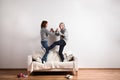 Beautiful senior couple standing on couch, dancing. Studio shot. Royalty Free Stock Photo