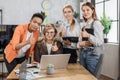 Beautiful senior female boss sitting at the table in office and listening to her diverse colleagues Royalty Free Stock Photo