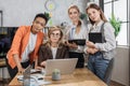 Beautiful senior female boss sitting at the table in office and listening to her diverse colleagues Royalty Free Stock Photo