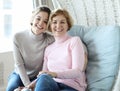 Beautiful senior mom and her adult daughter are hugging, looking at camera and smiling. Royalty Free Stock Photo