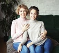 Beautiful senior mom and her adult daughter are hugging, looking at camera and smiling. Royalty Free Stock Photo