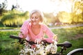 Beautiful senior woman with bicycle outside in spring nature. Royalty Free Stock Photo