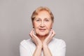 Beautiful senior woman holding her hands near her face and smiling Royalty Free Stock Photo