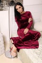 Beautiful sensual woman with dark hair wears elegant dress,posing in bedroom