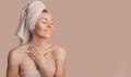 Beautiful sensual young girl with clean skin on a beige background with a mockup. Topless woman in a towel. The concept of spa Royalty Free Stock Photo