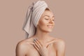 Beautiful sensual young girl with clean skin on a beige background with a mockup. Topless woman in a towel. The concept of spa Royalty Free Stock Photo