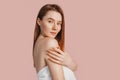 Beautiful sensual young girl with clean skin on a pink background with a mockup. Topless woman in a towel. The concept of spa Royalty Free Stock Photo