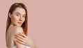 Beautiful sensual young girl with clean skin on a pink background with a mockup. Topless woman in a towel. The concept of spa Royalty Free Stock Photo