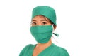 Beautiful and serious Asian Chinese medicine doctor woman or hospital nurse in medical hat surgeon face mask and green scrub in Royalty Free Stock Photo