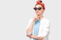 Beautiful serious brunette young woman wears black sunglasses, white shirt and trendy red headband Royalty Free Stock Photo