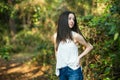 A beautiful serious teen brunette girl looking away from the camera towards the future in a wooded area in the spring Royalty Free Stock Photo