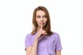 Beautiful serious young woman holding finger at her lips, saying Shh, Hush, demanding keeping secret and holding tongue Royalty Free Stock Photo