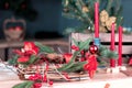 Beautiful served dining table with decorations, red candles and lanterns, Christmas tree blurred background, festive mood