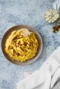 Beautiful serving of chickpea hummus with olive oil, garlic, spices and roasted grains on kitchen table with cotton napkin, Royalty Free Stock Photo