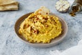 Beautiful serving of chickpea hummus with olive oil, garlic, spices and roasted grains on kitchen table with cotton napkin, food Royalty Free Stock Photo