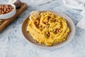 Beautiful serving of chickpea hummus with olive oil, garlic, spices and roasted grains on kitchen table with cotton napkin, food Royalty Free Stock Photo