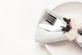 Beautiful set of cutlery knife and fork on a plate on a white wooden table. Royalty Free Stock Photo