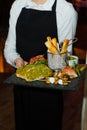 Beautiful set of food in the hands of a young waiter in a restaurant
