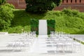 Beautiful setting for outdoors wedding ceremony waiting for bride and groom and guests. Wooden chairs decorated with Royalty Free Stock Photo