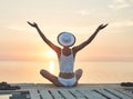 Beautiful sexual woman in white hat and bikini on a wooden pier against the sea and sunset Royalty Free Stock Photo