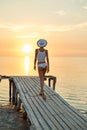 Beautiful sexual woman in white hat and bikini on a wooden pier Royalty Free Stock Photo
