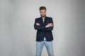 Beautiful sexy bearded man with a beautiful hair style. he is standing serious with crossed hands and looks at the camera. dressed