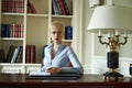 Beautiful sexy blonde woman in library parlor office read book meetings wear skinny skirt and blouse interior room classic style