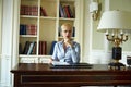 Beautiful sexy blonde woman in library parlor office read book meetings wear skinny skirt and blouse interior room classic style