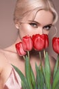 Beautiful sexy Blonde Woman with luxury Make-up. Girl with Spring Flowers Bouquet. Style for Womans Day or Valentines